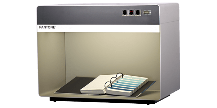 A square gray light booth, or lighting box, with a binder and color swatches.
